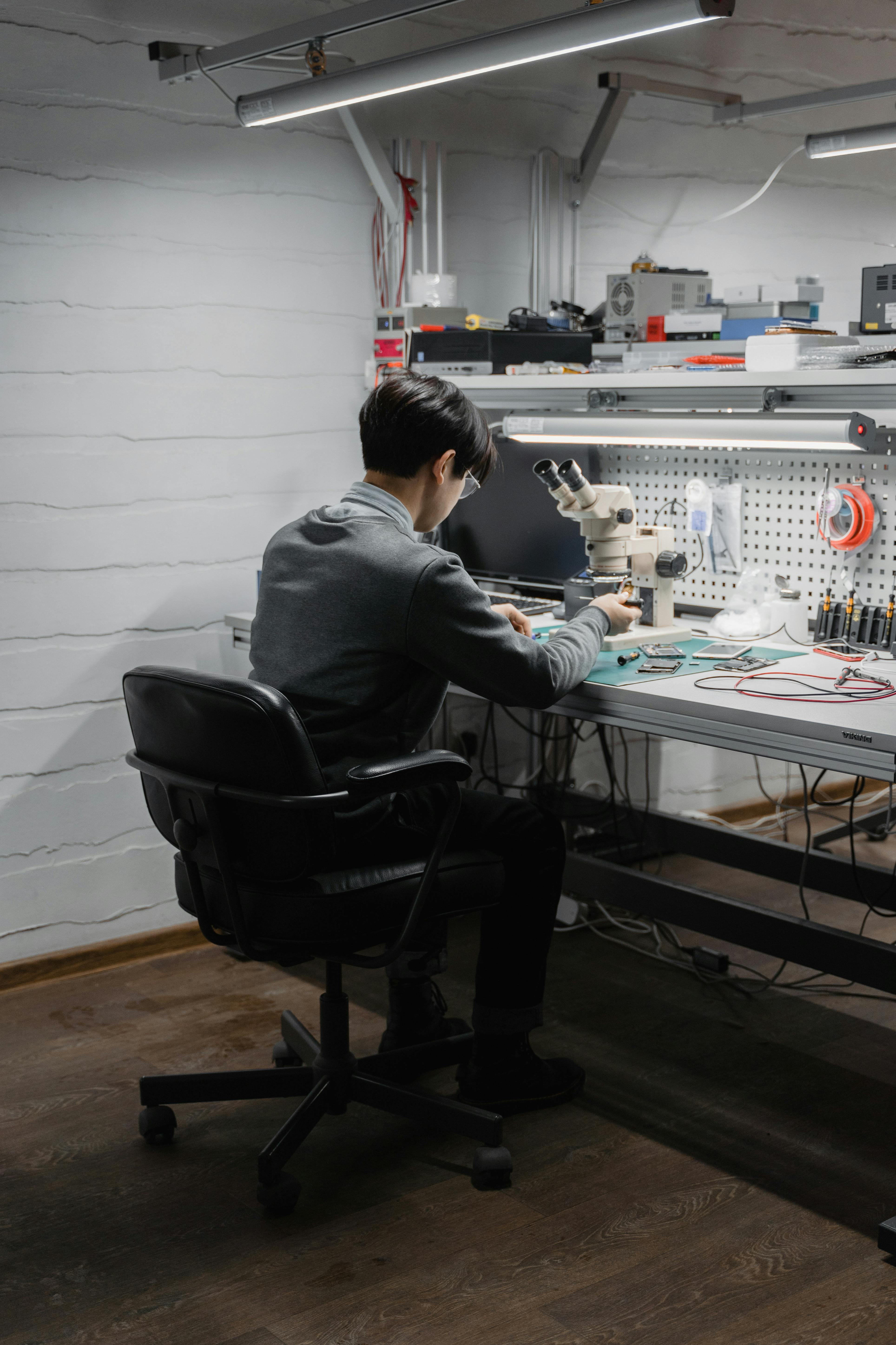 An engineer focusing on a project in a well-equipped electronics workspace.